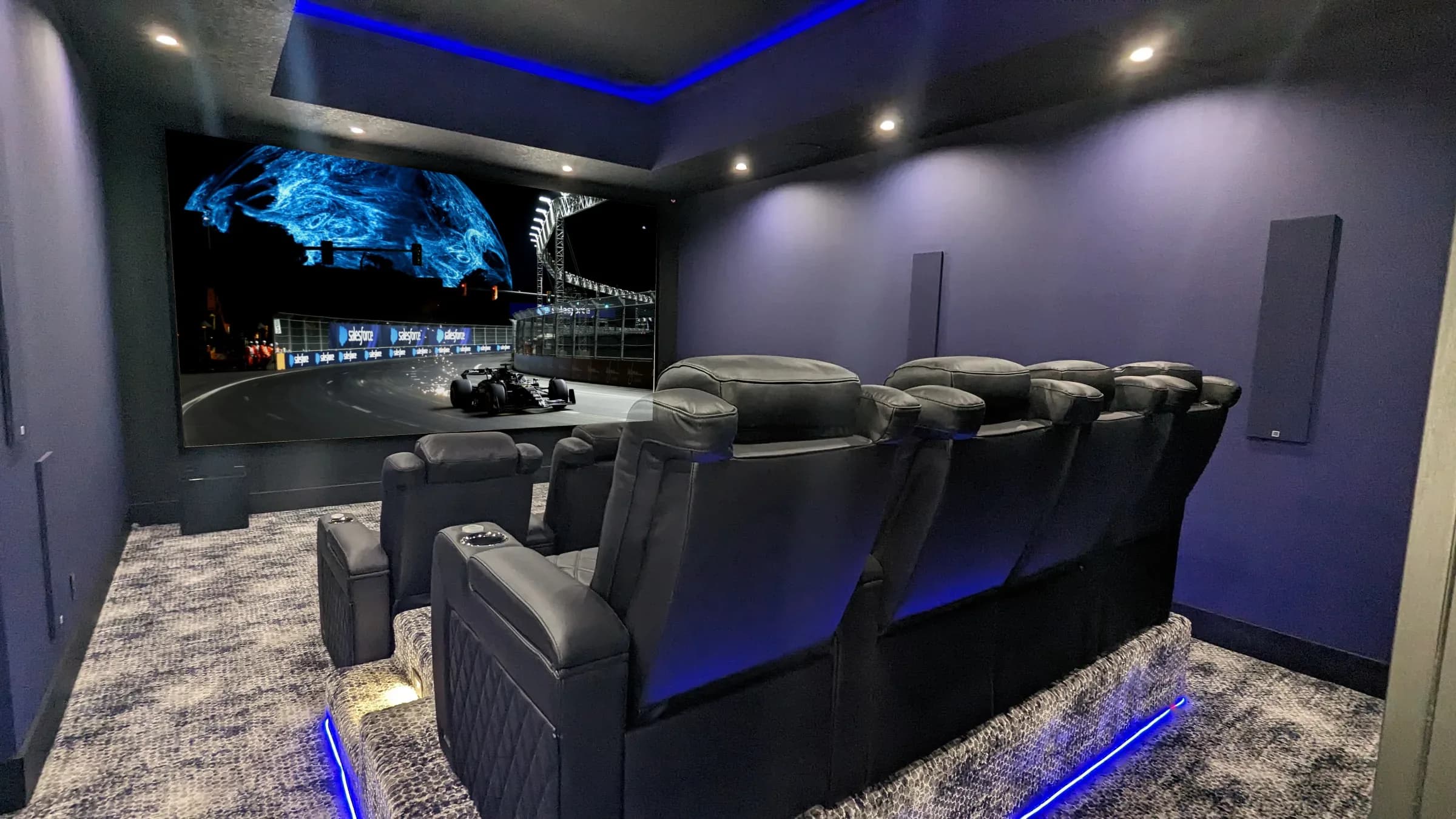 Private cinema room with tiered seating, acoustic treatment and a projection screen